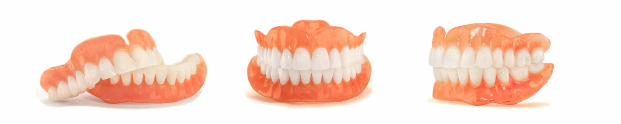 Three removable dentures displayed on a white background