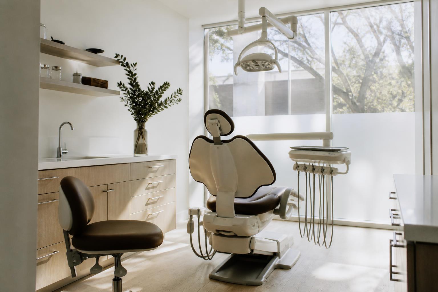 Modern dental treatment room with overhead exam light and instrument tray